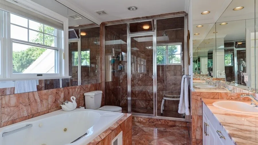 Un baño con bañera, ducha de vidrio y tocador con espejo.