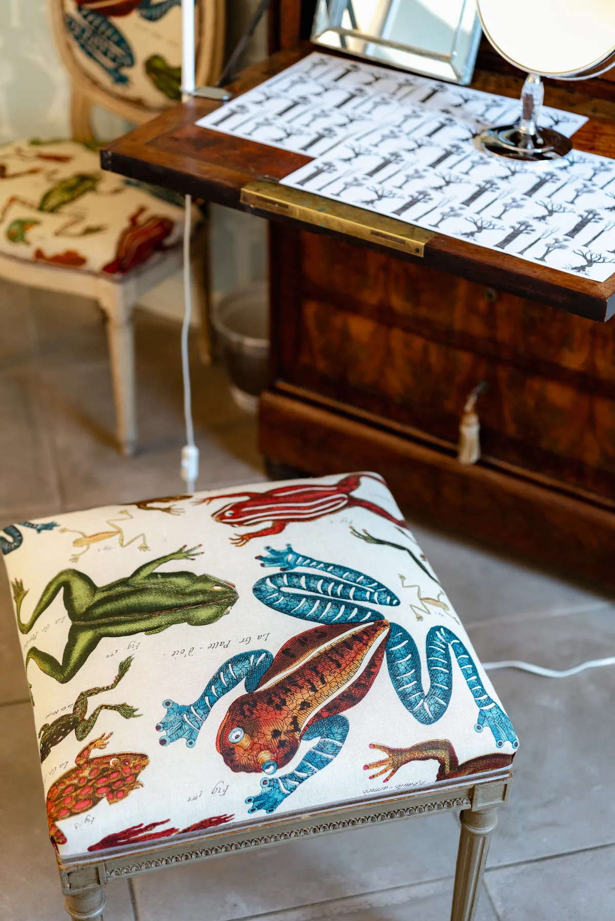 A furnished room with a cushioned stool covered in colorful animal illustrations.