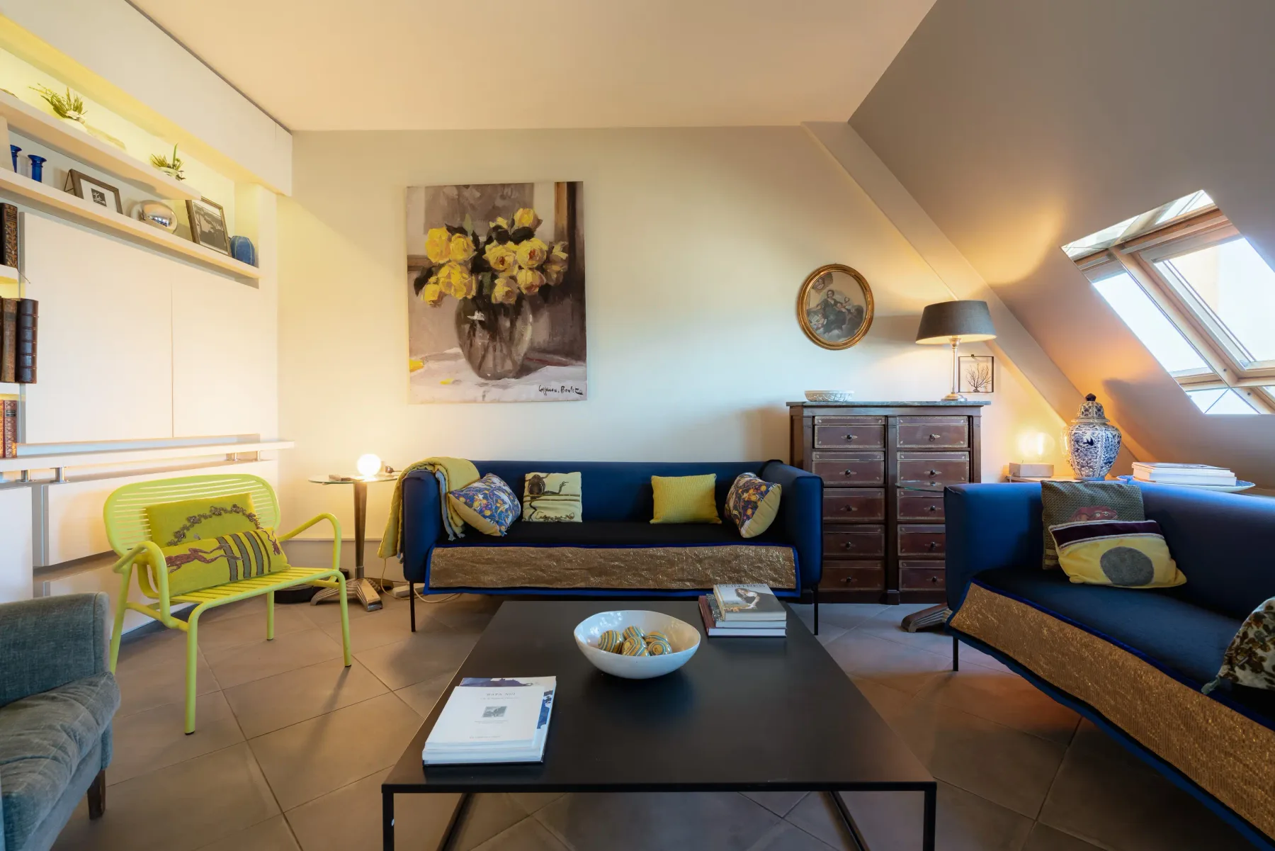 A bright attic living room with seating arranged around a low coffee table.