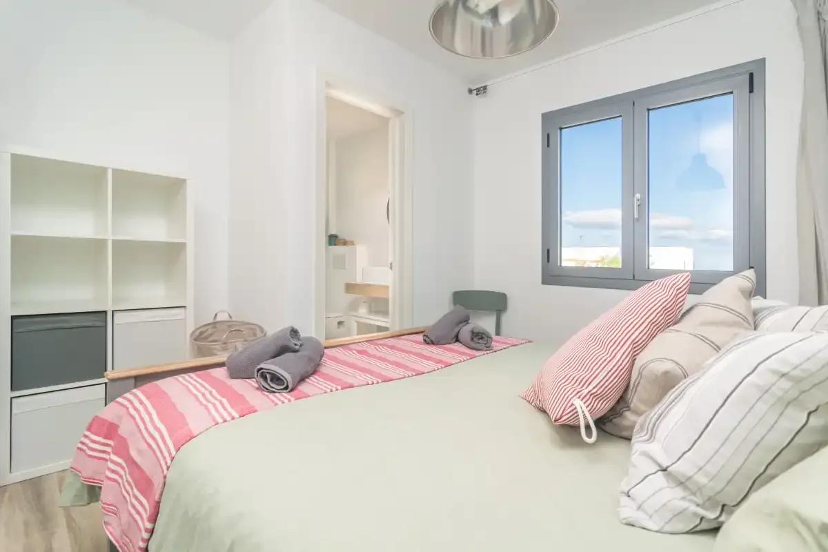 Un dormitorio con una cama y una ventana con vistas al mar.