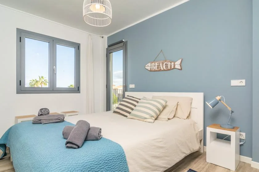 Un dormitorio con una cama bien tendida y una ventana.