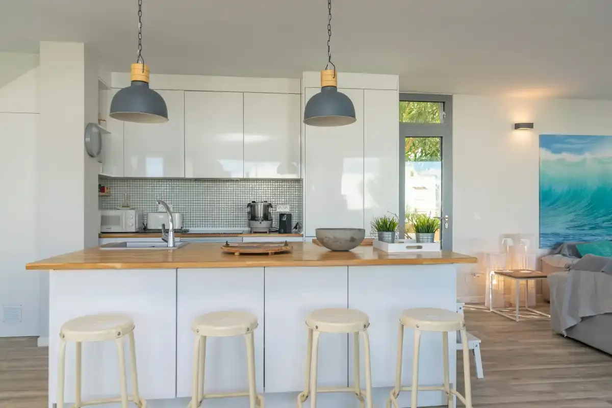Una cocina luminosa con una barra para desayunar y una zona de estar abierta.
