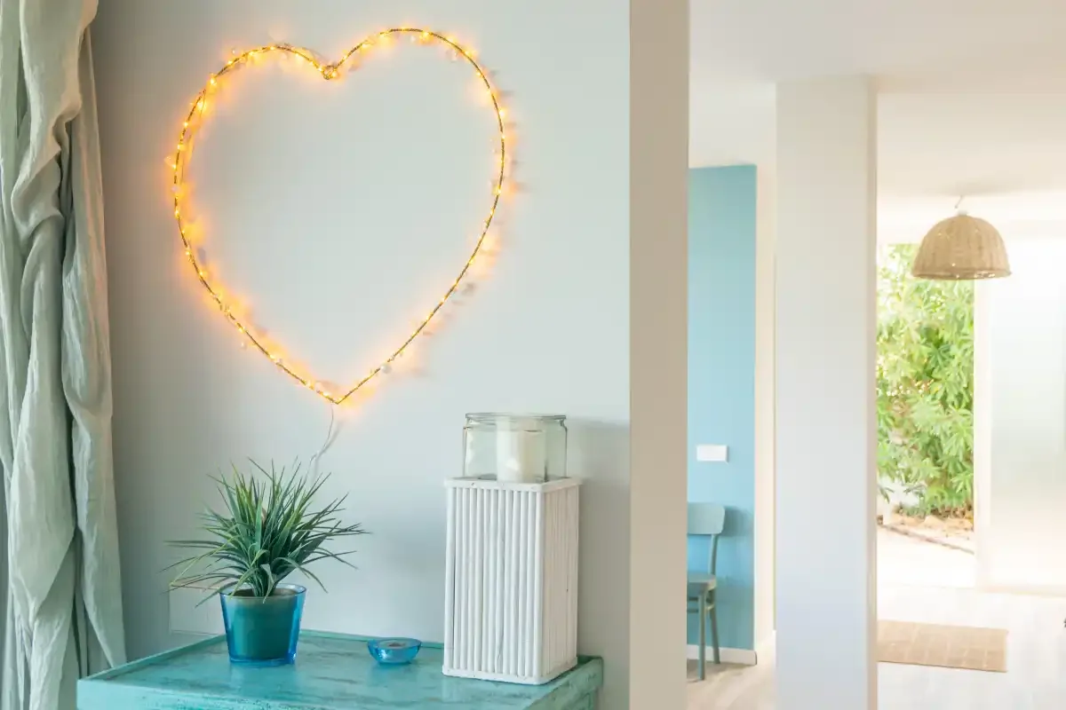 Un interior luminoso con una luz en forma de corazón sobre una mesa pequeña.