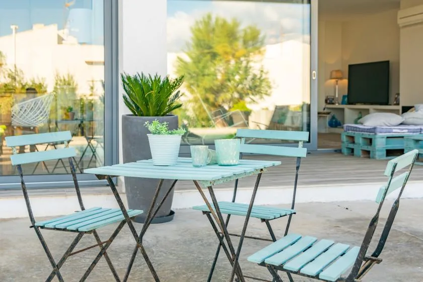 Una zona de estar en el patio da a una habitación luminosa a través de grandes puertas de vidrio.