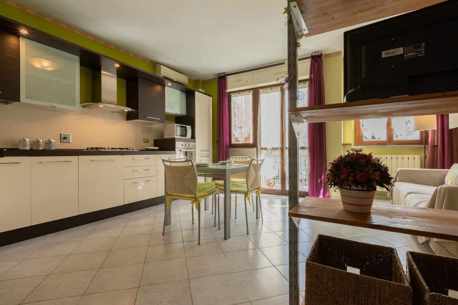 Una cocina y comedor con una mesa junto a puertas de vidrio.