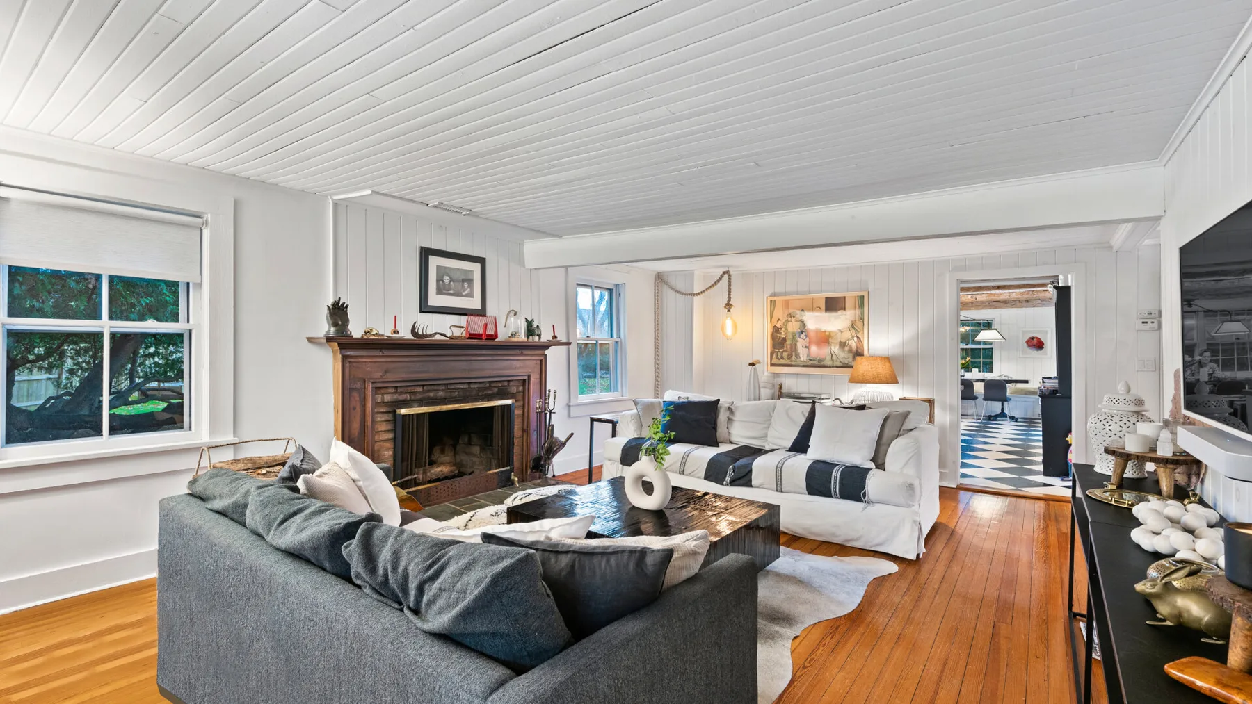 A bright living room with seating arranged around a fireplace and coffee table.
