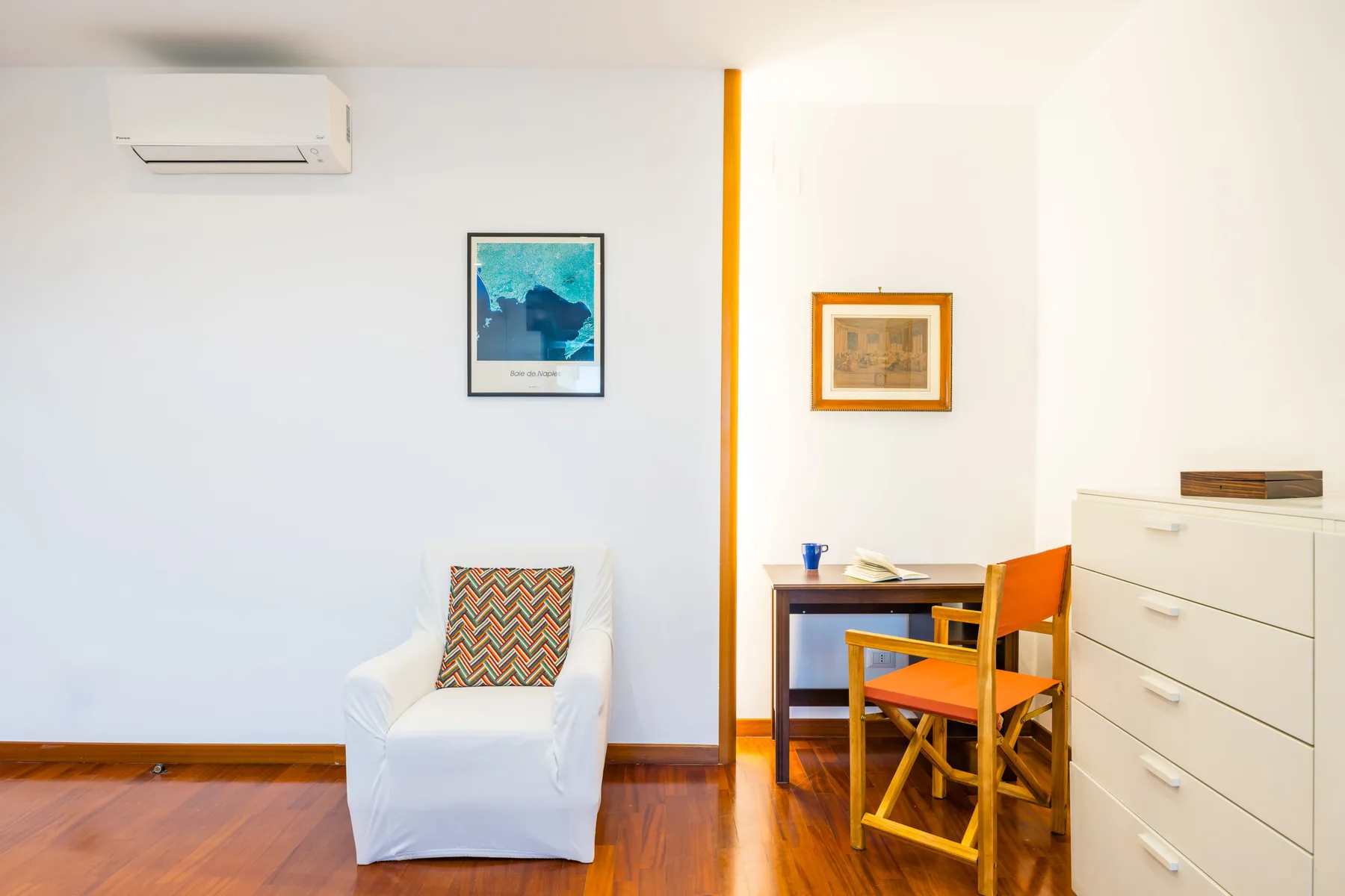 A bright room with a white armchair and a small wooden table.