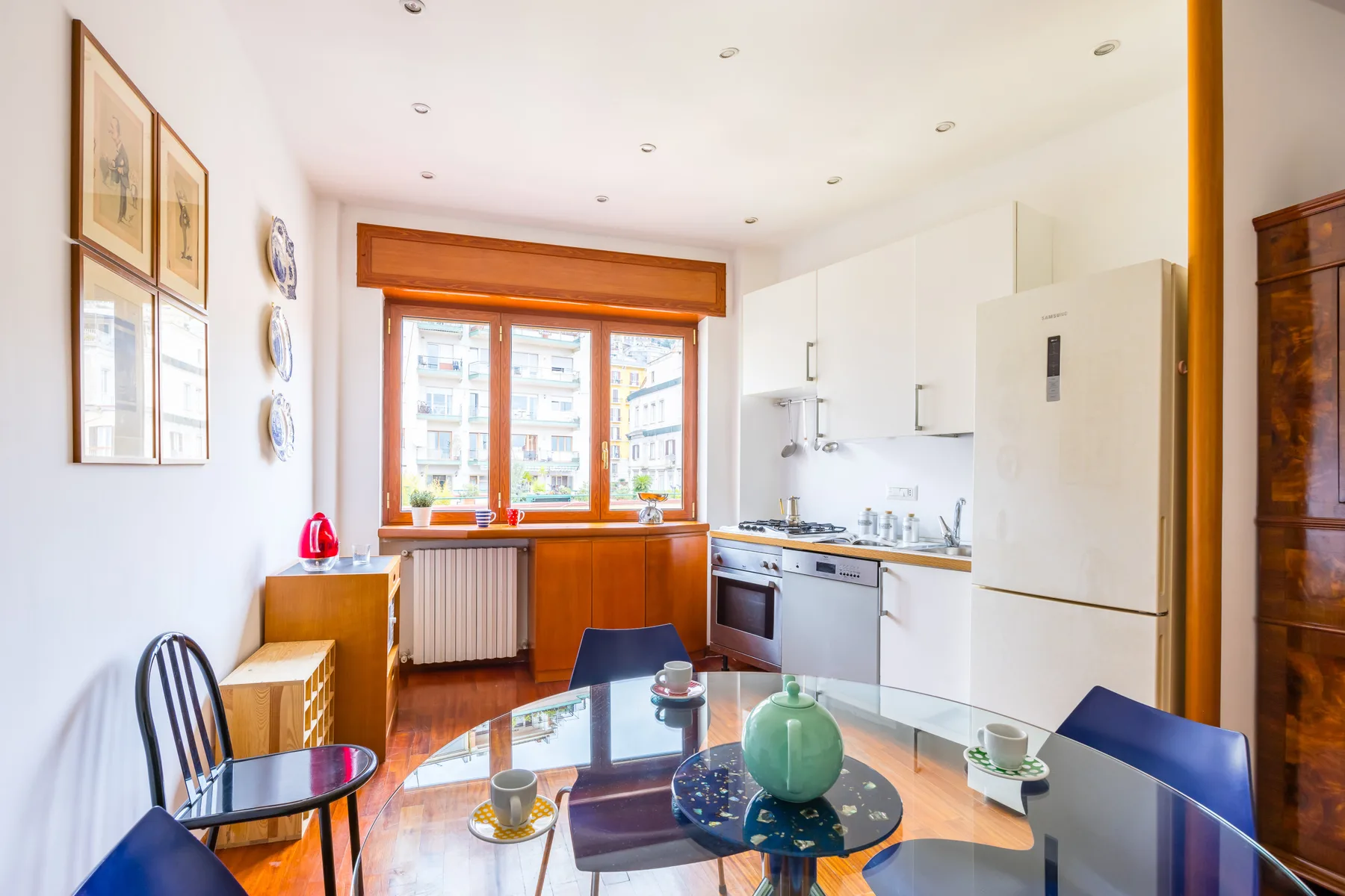 A bright kitchen and dining area with a table beside the window.