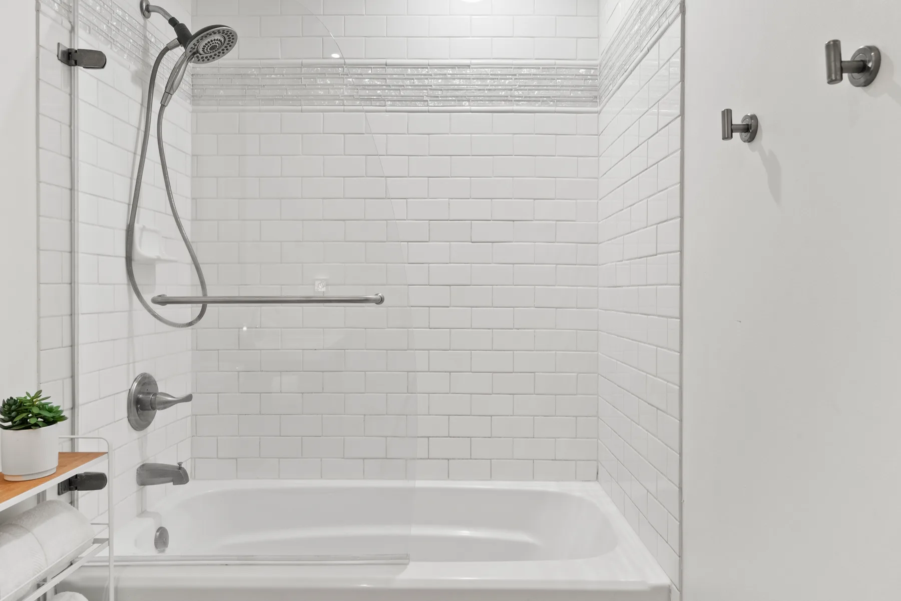 Una ducha de baño con azulejos, bañera y ducha de mano.