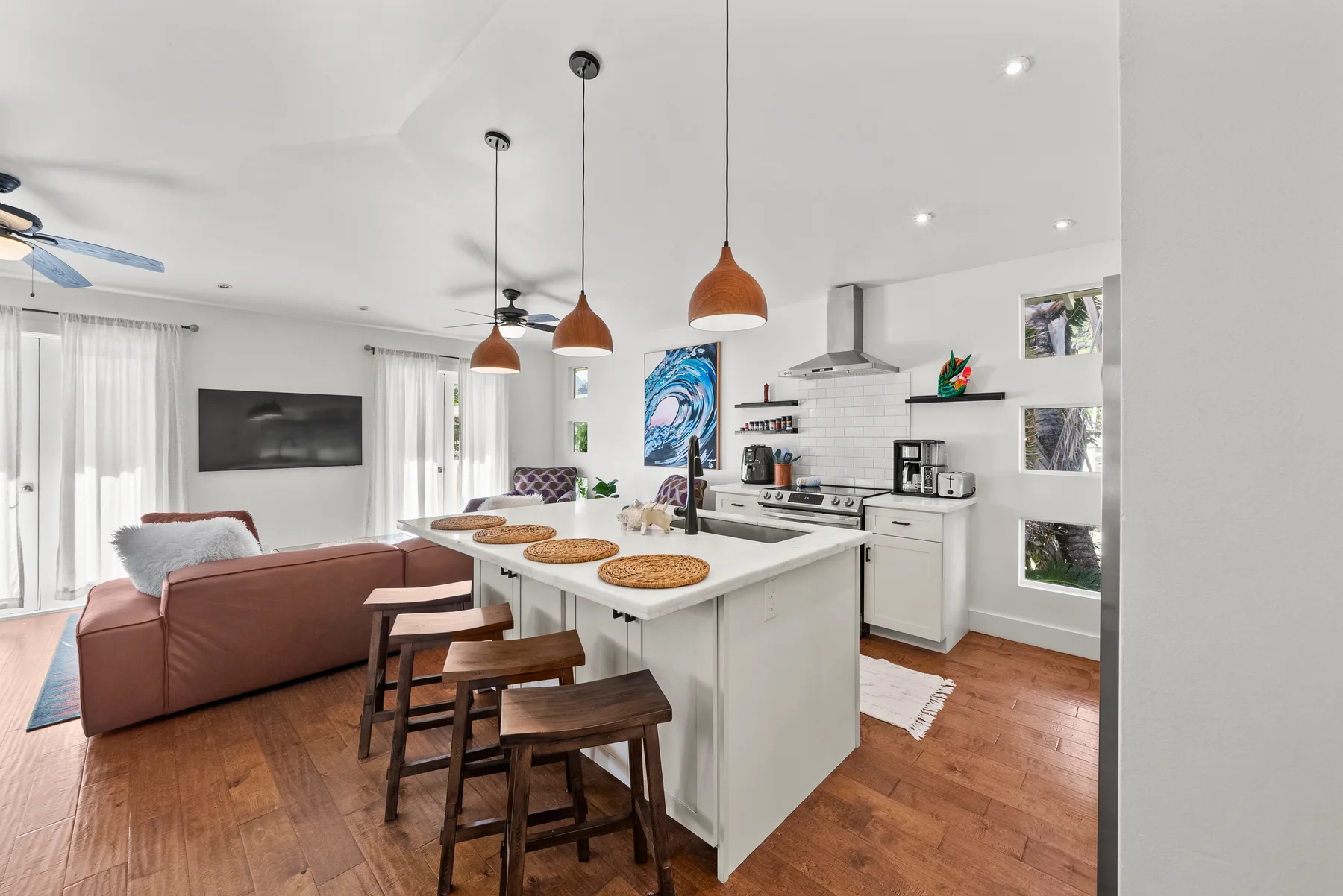 Cocina y sala de estar de concepto abierto con isla y asientos.