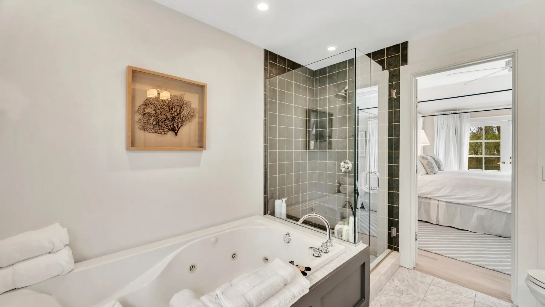 A bathroom with a bathtub beside a glass shower.