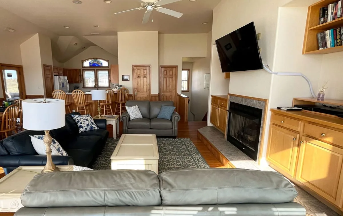 A living room with seating, a fireplace, and a television.