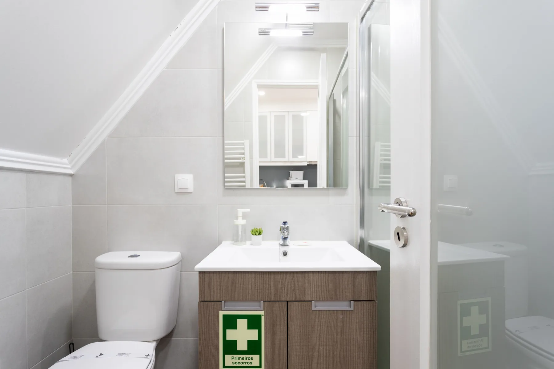 Un baño luminoso con lavabo, espejo e inodoro.
