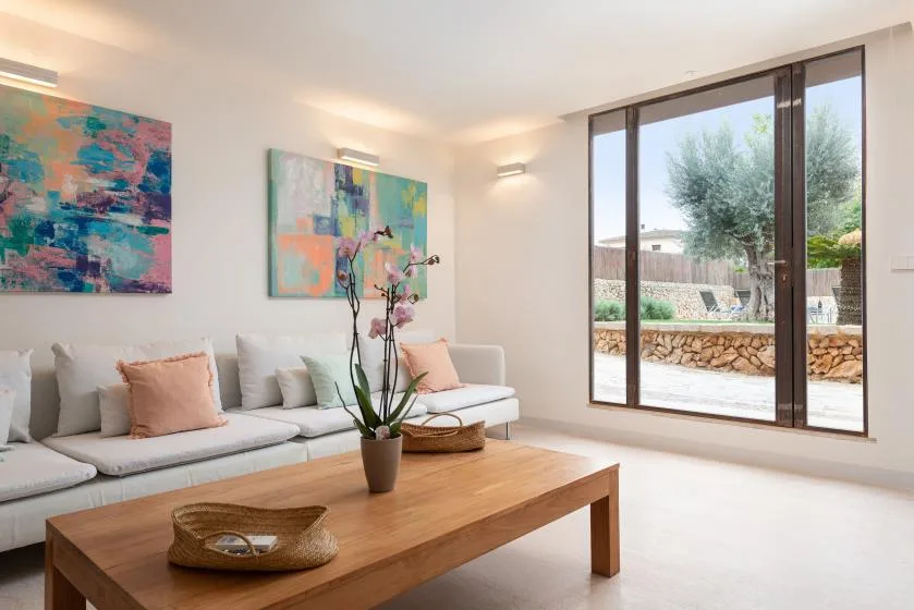 Una sala luminosa con asientos, arte colorido en las paredes y una ventana amplia.
