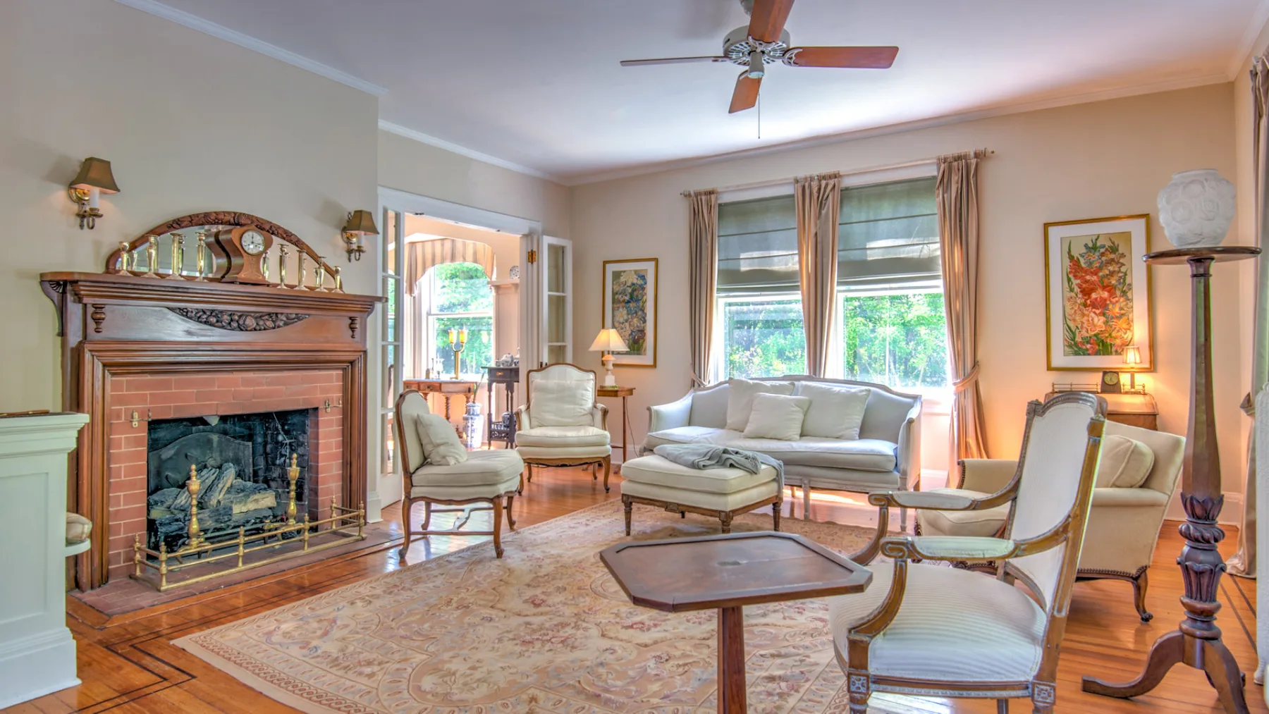 A living room with seating arranged around a fireplace and coffee table.