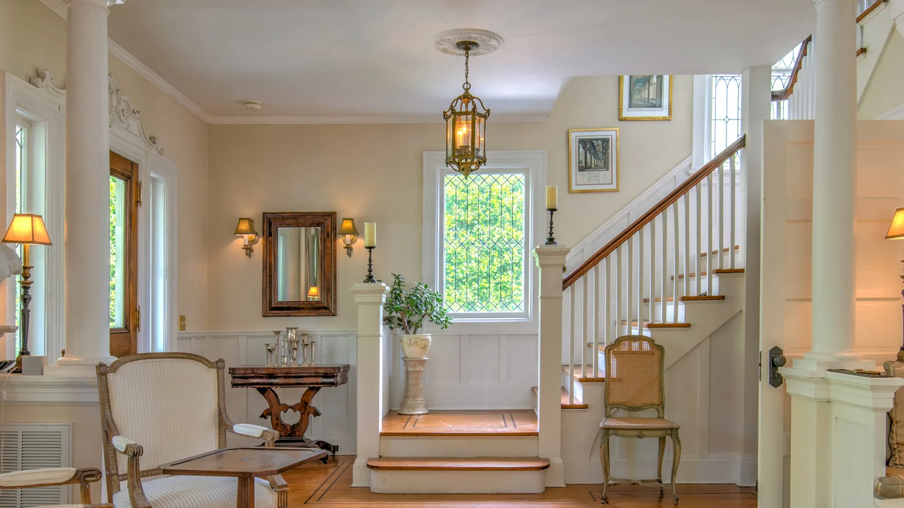 A bright entry hall with a staircase and a large window.