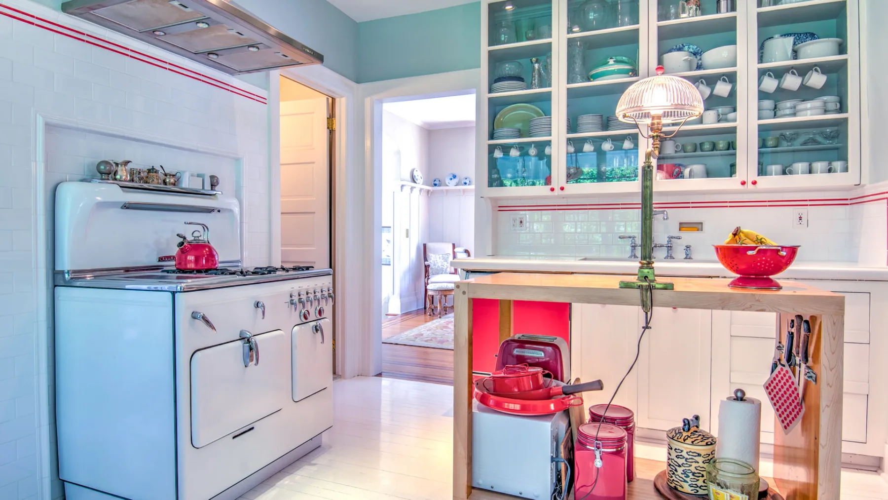A bright kitchen with a large island and glass-front cabinets.