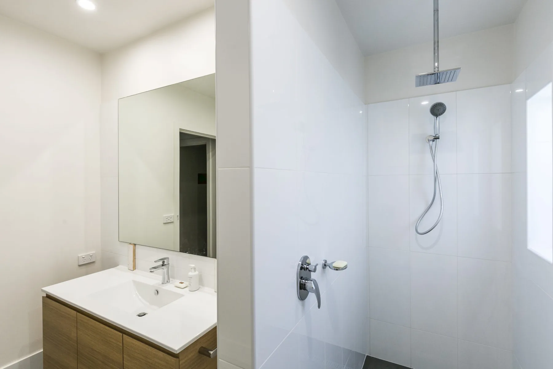 Un baño luminoso con lavabo y ducha.