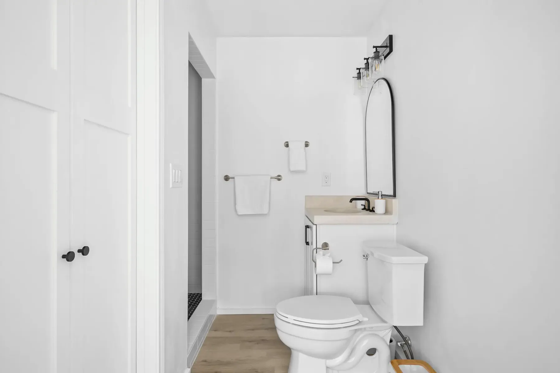 A bright bathroom with a toilet, sink, and wall mirror.