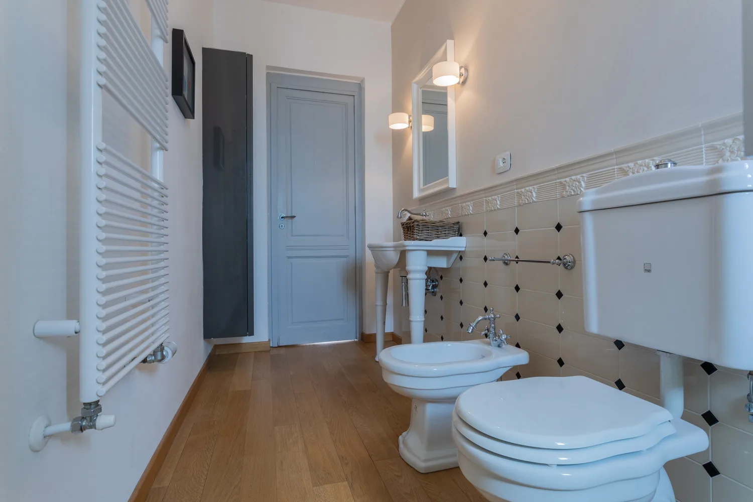 Un baño con bañera, bidé y radiador blanco.