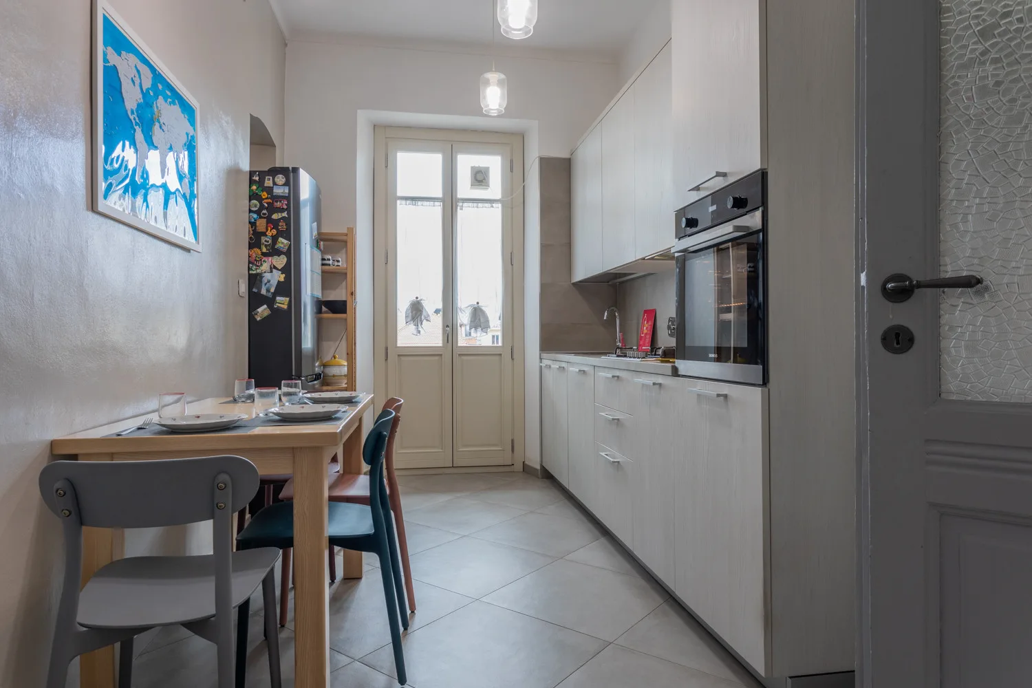 Una cocina estrecha con zona de comedor y una mesa junto a los armarios.