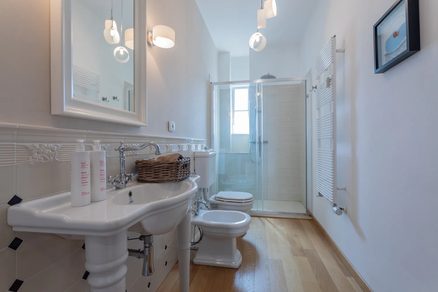 Un baño luminoso con lavabo, inodoro y ducha de vidrio.
