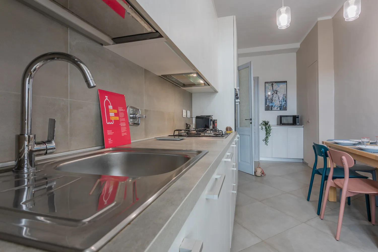 Una cocina moderna con fregadero de acero inoxidable y una pequeña zona de comedor.