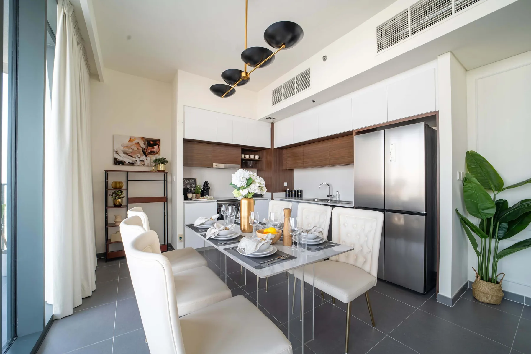 Comedor con la mesa puesta junto a una cocina moderna.