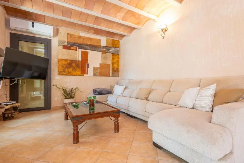 Una sala de estar con un sofá seccional grande y una mesa de centro de madera.