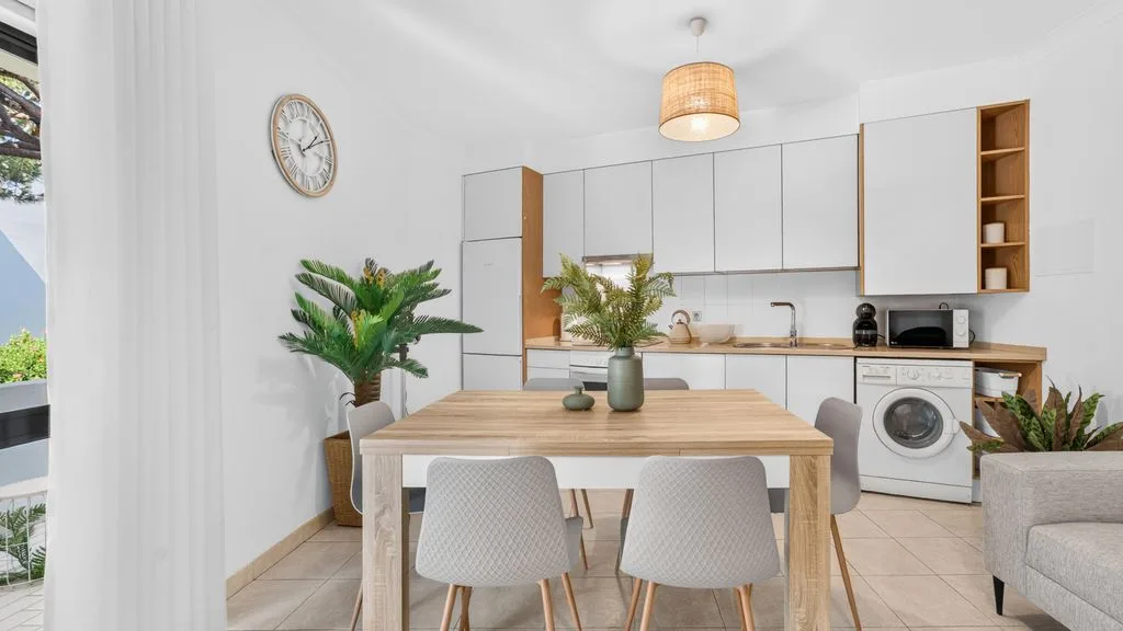 A bright kitchen and dining area with a wooden table and built-in cabinets.