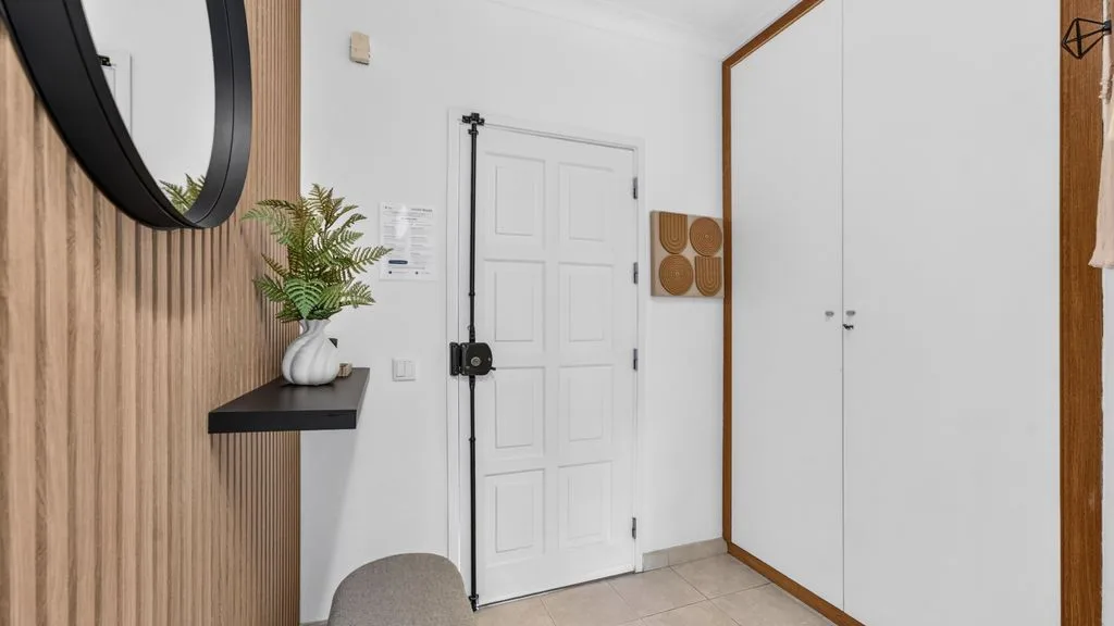 An entryway with a white door, built-in storage, and a narrow console table.