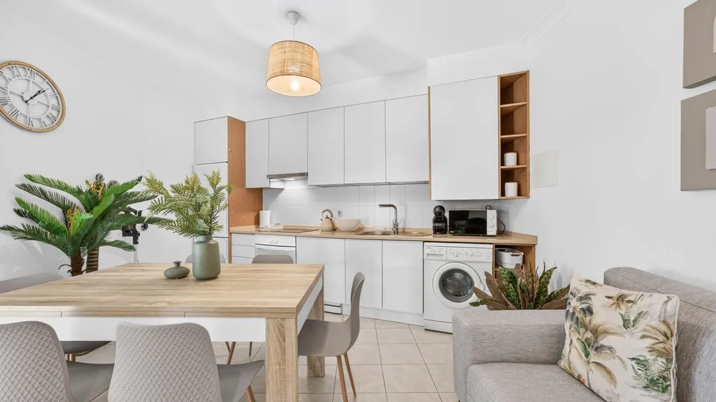 A bright dining and kitchen area with a table and seating.