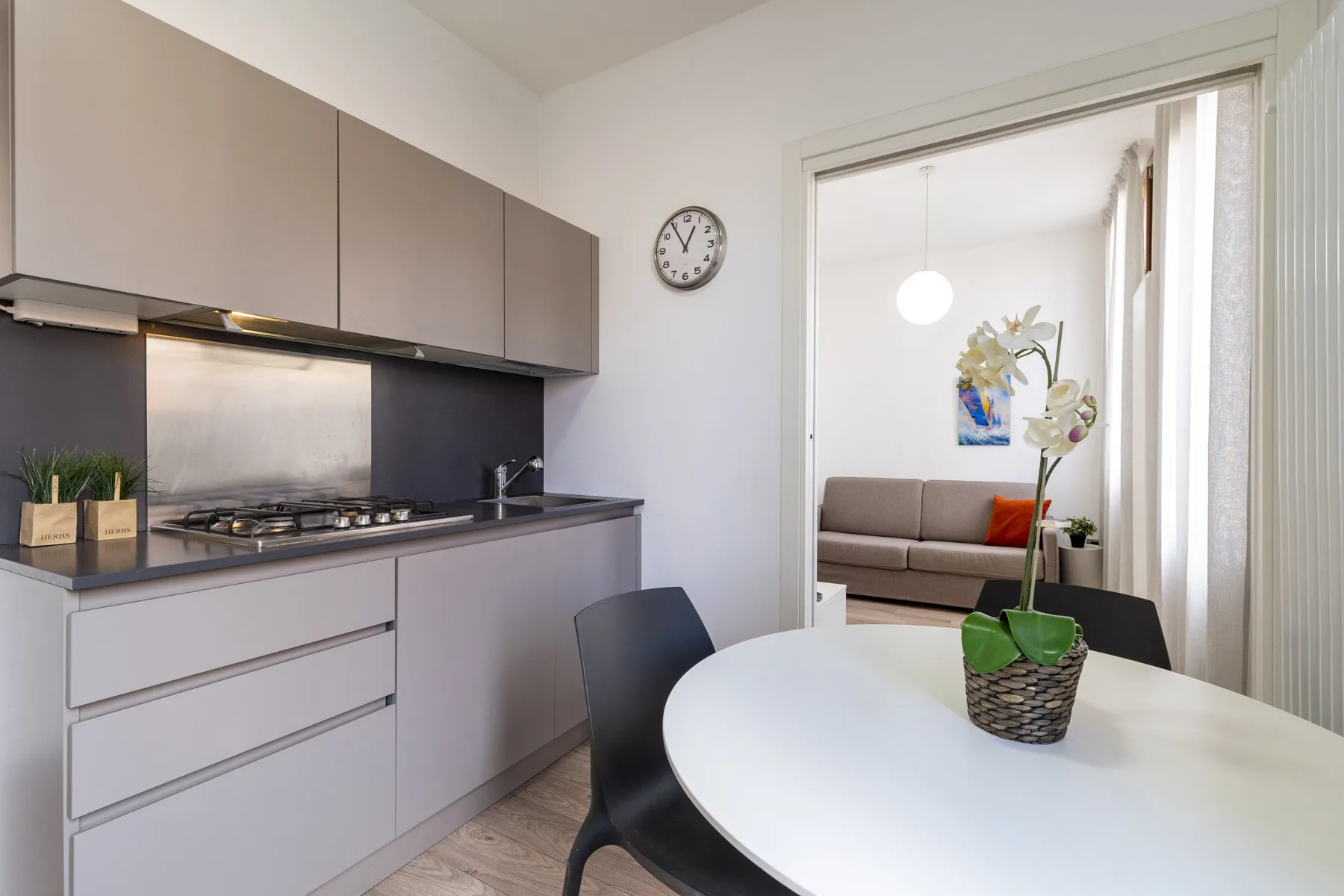 A dining area with a white table and an open view into a living area.