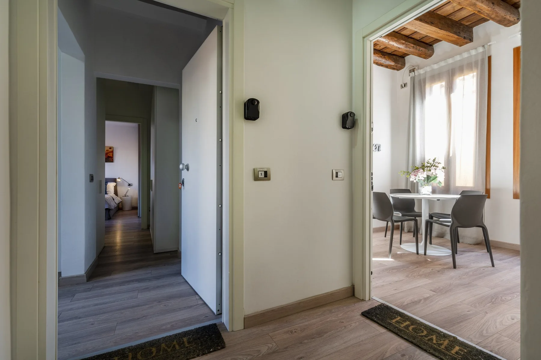 A hallway opens into a bright dining area with a table and chairs.
