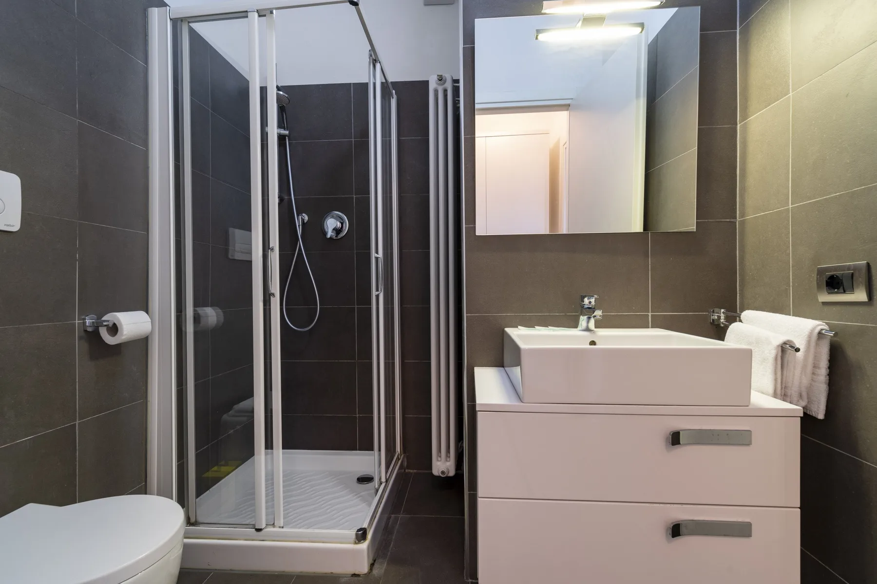 A modern bathroom with a glass-enclosed shower and a sink vanity.