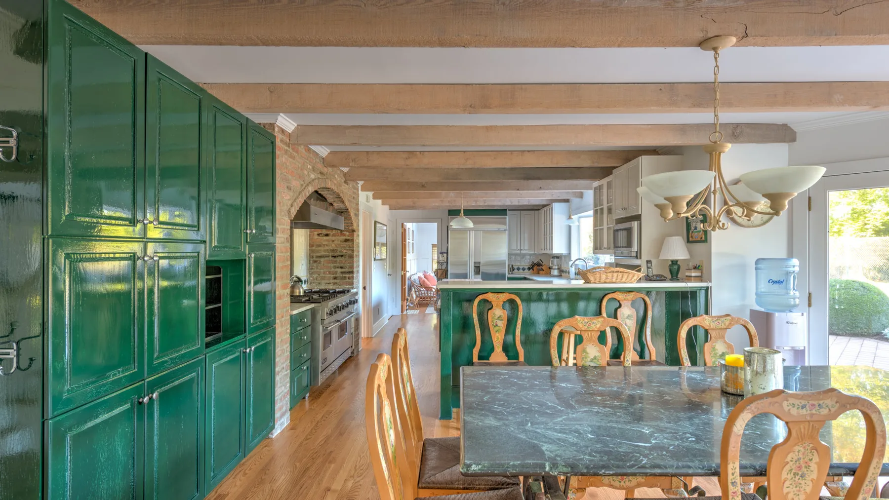 A kitchen and dining area with green cabinetry and a large dining table.