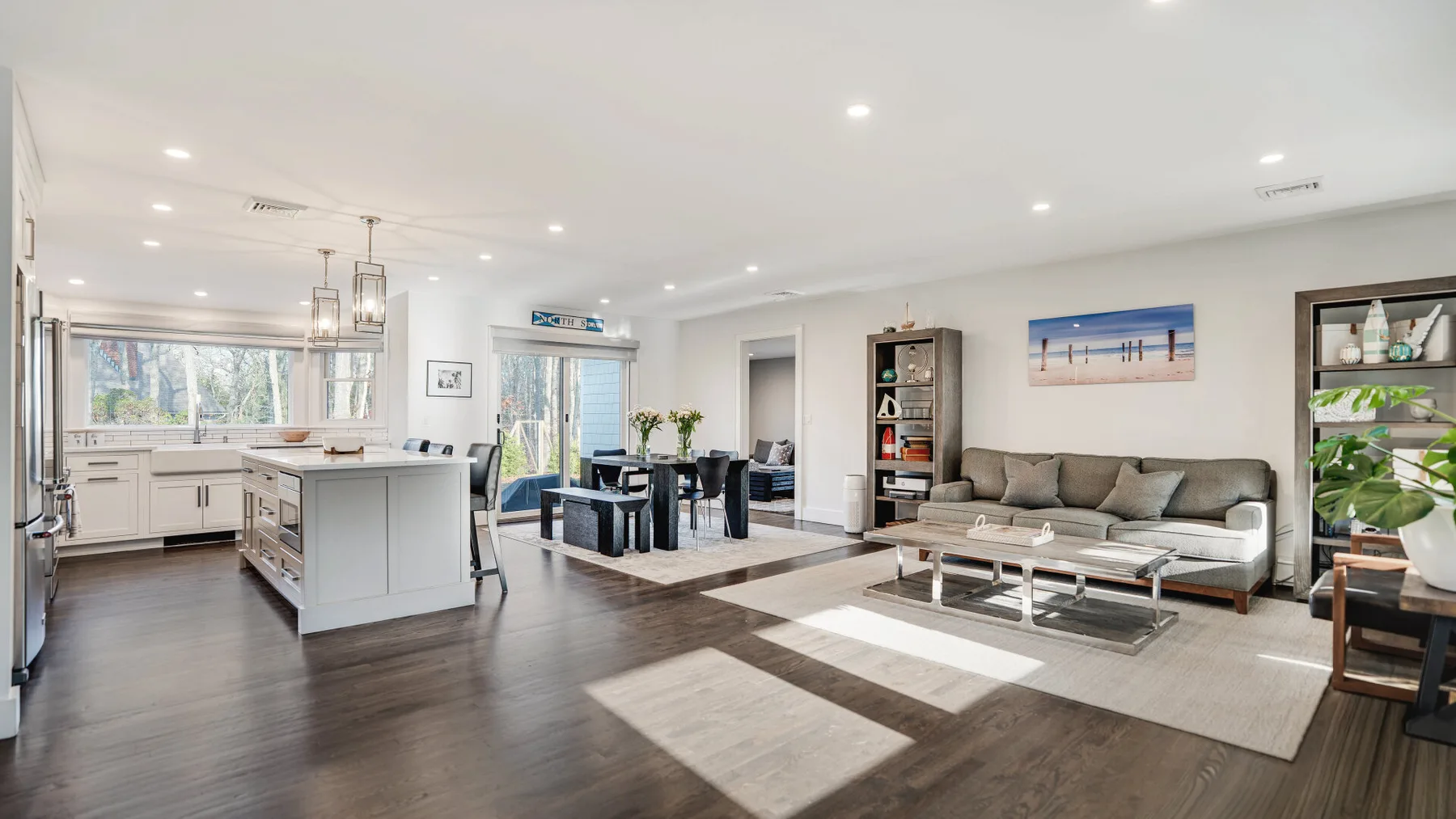 An open-plan living room and kitchen with a dining table and seating.