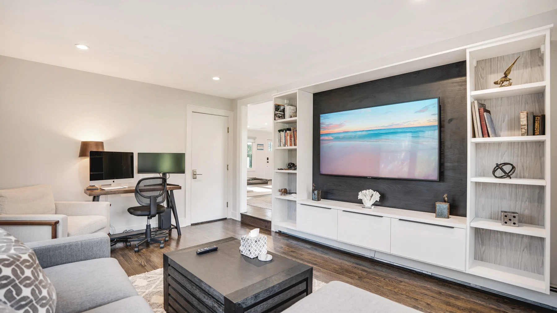 A living room with a television mounted above a low cabinet.