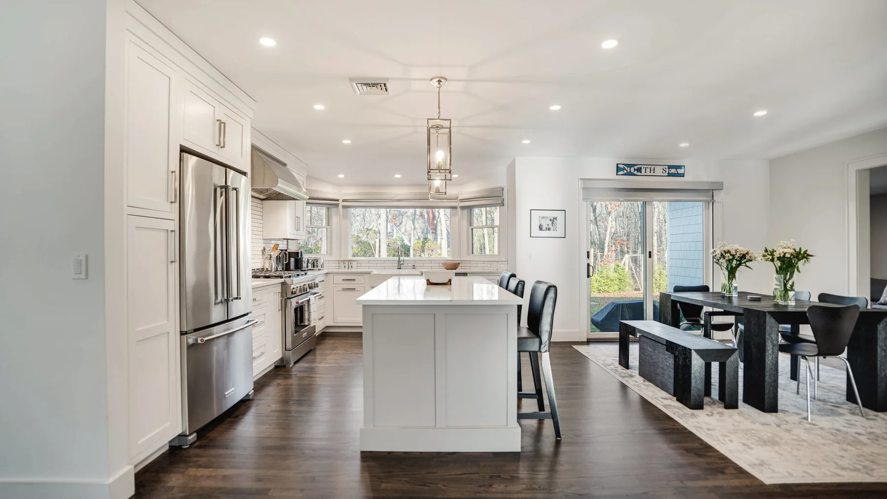 A bright open-plan kitchen and dining area with a central island and dining table.