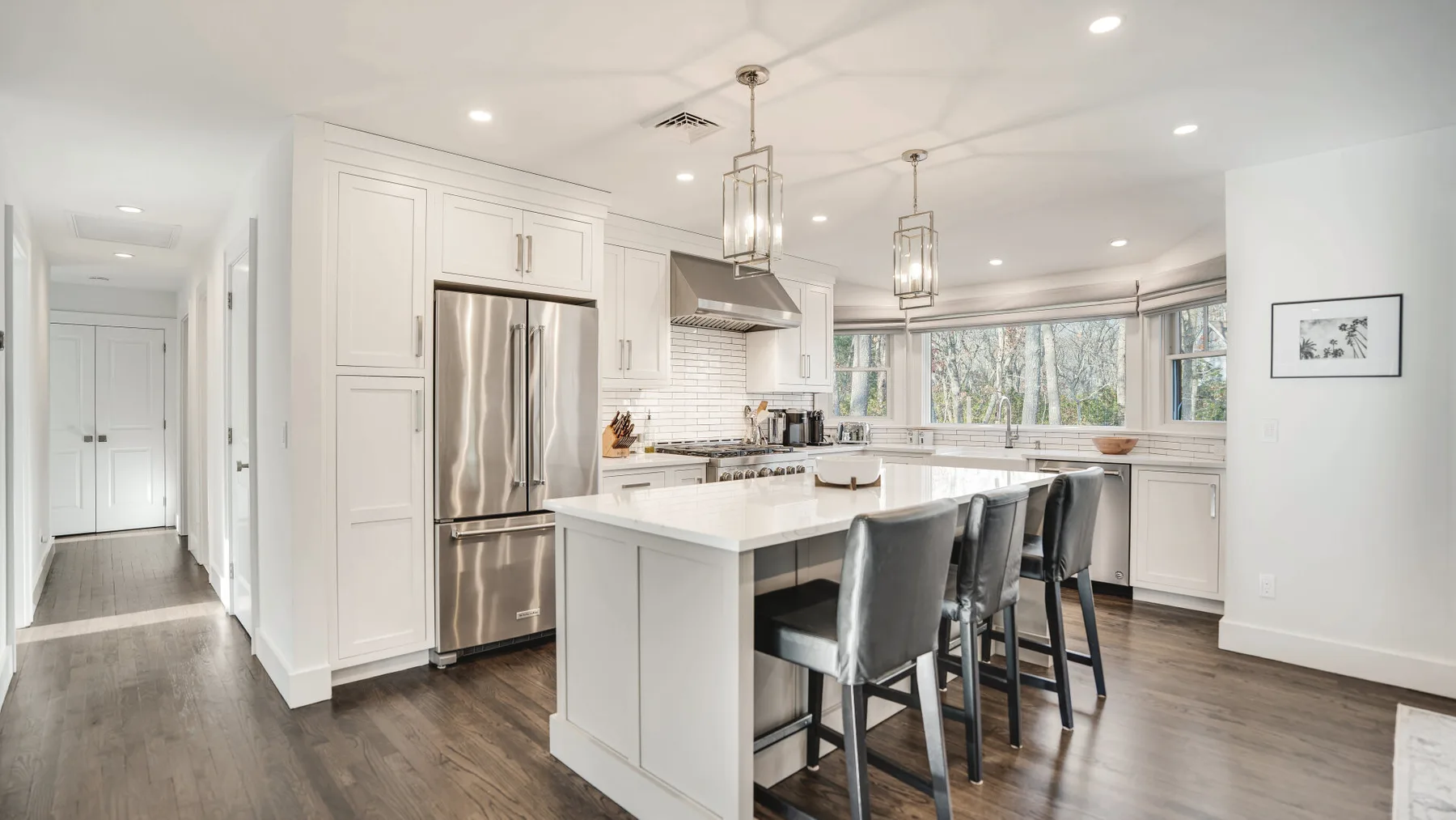 A bright kitchen with a large island, bar seating, and wide windows.