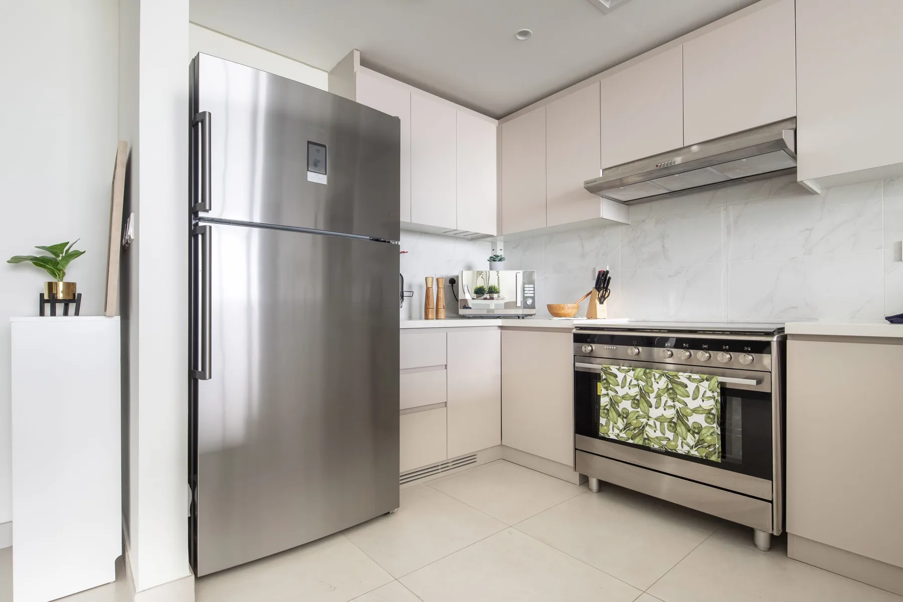 A modern kitchen with stainless steel appliances and pale cabinetry.
