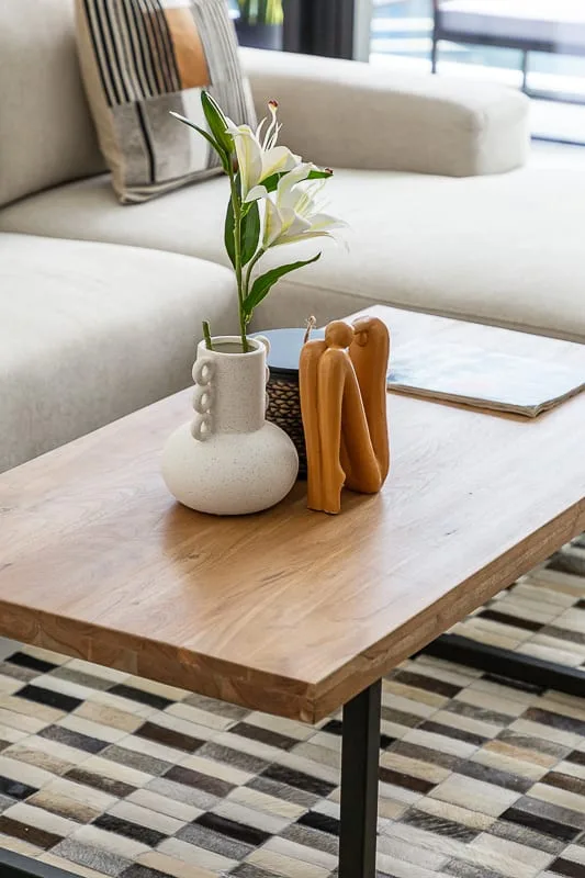 Una zona de estar con una mesa de centro de madera y un jarrón decorativo.