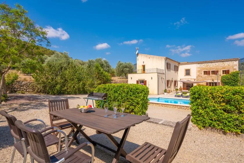 Un patio al aire libre con asientos da a una piscina y un edificio de piedra.