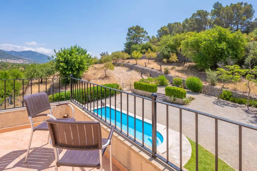Una piscina y asientos en el patio dan a una ladera ajardinada.