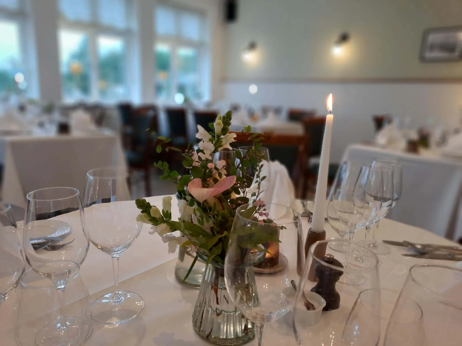 Mesas de comedor decoradas con flores y velas.