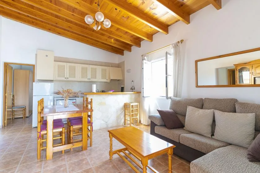 Una sala de estar con asientos, una mesa de centro y un comedor contiguo.