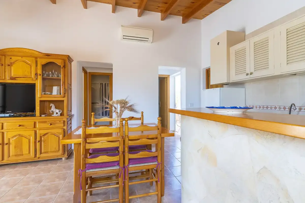 A dining area with wooden seating beside a kitchen counter and cabinets.