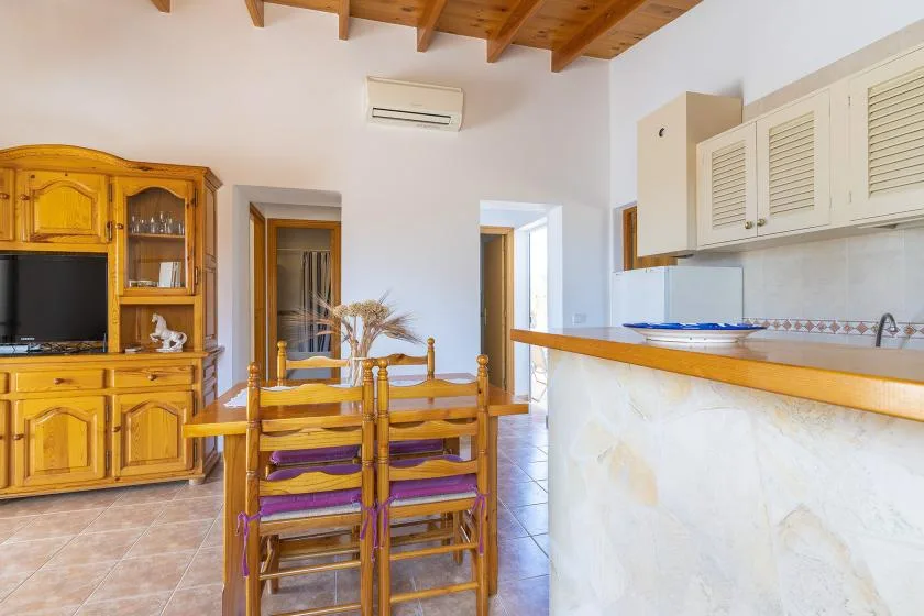 A dining area with wooden seating beside a kitchen counter.