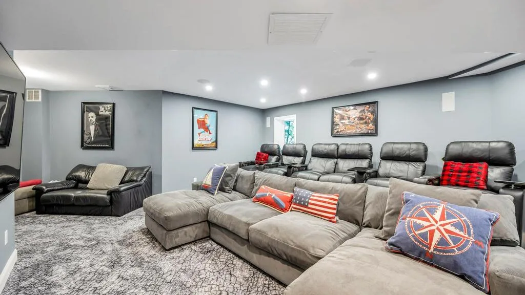 A home theater with rows of seating and framed artwork on the walls.