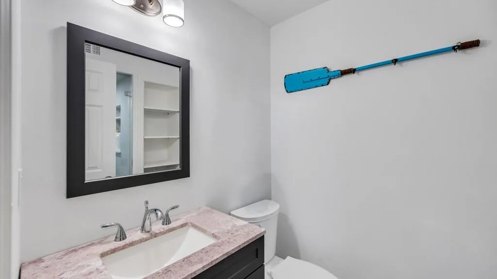 A bathroom with a sink, mirror, and toilet.